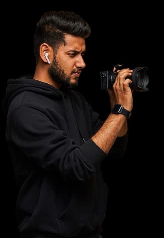 Photographer in a black hoodie shooting with a DSLR